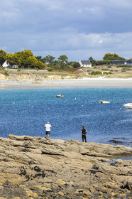 Pêcheur sur la pointe de Kerjean sur la commune de Trégunc. En arrière-plan, la plage de Kersidan