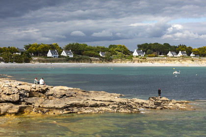 Pêcheur sur la pointe de Kerjean sur la commune de Trégunc. En arrière-plan, la plage de Kersidan