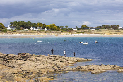 Pêcheur sur la pointe de Kerjean sur la commune de Trégunc. En arrière-plan, la plage de Kersidan